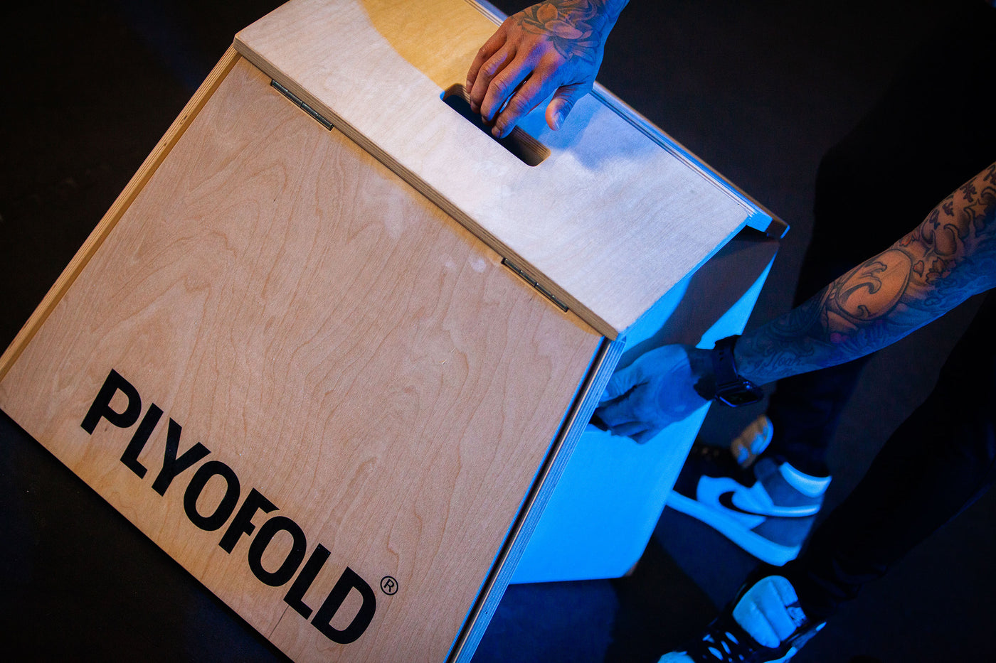 Man folding up a portable plyo box